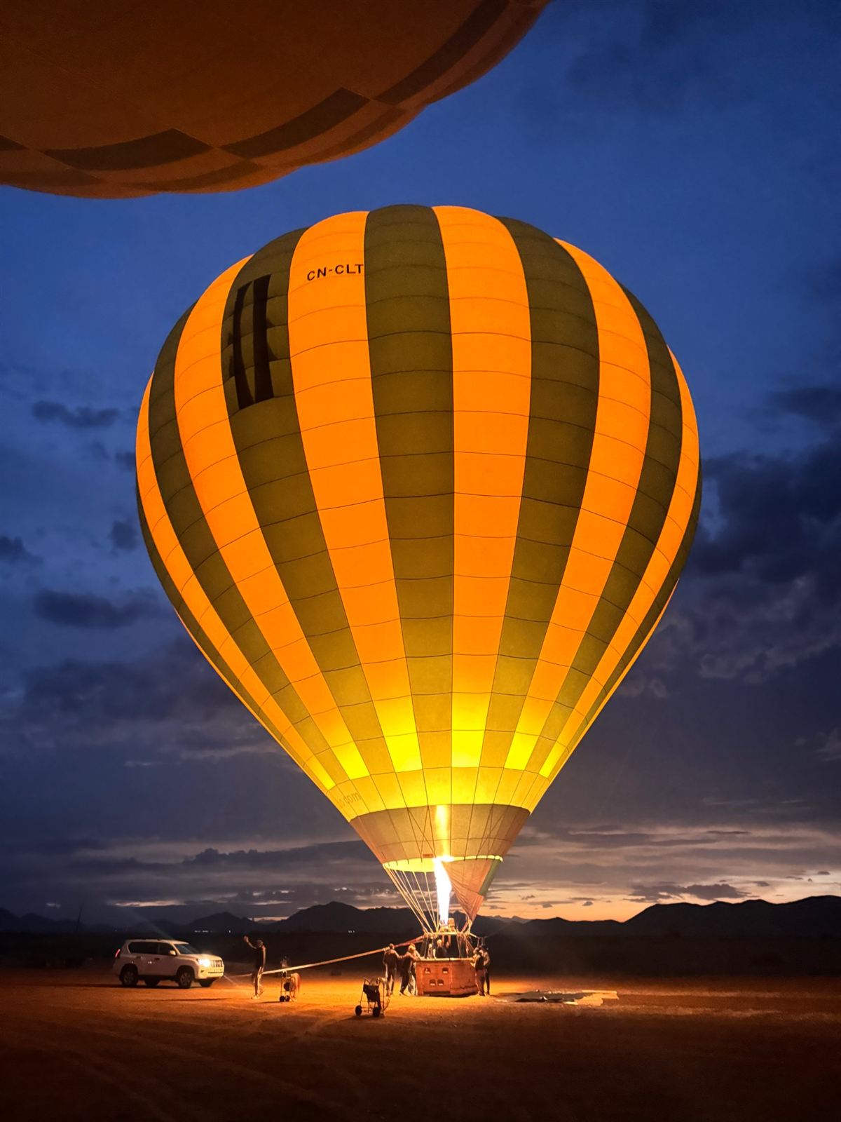 Balloon lit up by its burner before dawn